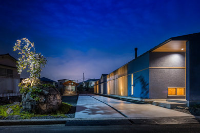 Modelo de fachada de casa azul minimalista de una planta con revestimiento de estuco, tejado a dos aguas y tejado de metal