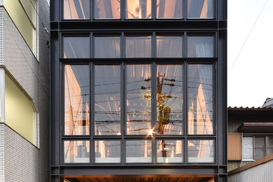 Black urban house exterior in Nagoya with three floors and a flat roof.