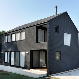 Photo of an asian two-storey black house exterior in Other with a gable roof and a shingle roof.
