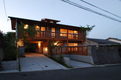 Ejemplo de fachada de casa blanca asiática de tamaño medio de dos plantas con revestimiento de estuco, tejado a dos aguas y tejado de metal