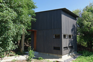 Foto de fachada gris escandinava pequeña de una planta con revestimiento de madera, tejado de un solo tendido y tejado de metal