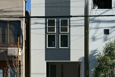 Ejemplo de fachada de casa moderna pequeña de dos plantas con revestimientos combinados, tejado de un solo tendido y tejado de metal