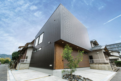 Modelo de fachada de casa negra minimalista de tamaño medio de dos plantas con revestimiento de metal, tejado de un solo tendido y tejado de metal