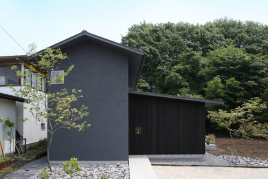 Modelo de fachada de casa negra minimalista de tamaño medio de dos plantas con tejado a dos aguas y tejado de metal