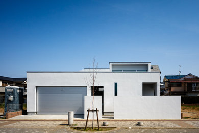 Inspiration for a modern white two-story concrete house exterior remodel in Tokyo with a shed roof and a metal roof