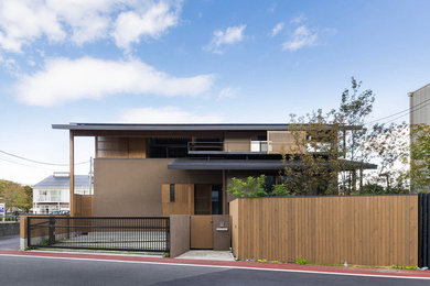 Foto de fachada de casa beige asiática de dos plantas con tejado a dos aguas y tejado de metal