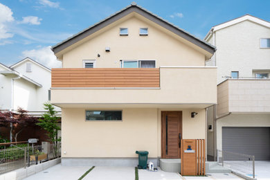 東京23区にあるカントリー風のおしゃれな家の外観 (黄色い外壁) の写真