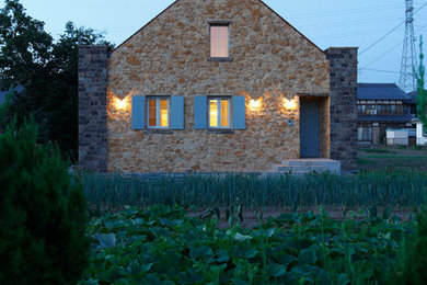 Idées déco pour une façade de maison marron campagne en pierre à un étage avec un toit à deux pans.