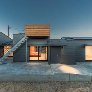Foto de fachada de casa gris, contemporánea, extra grande, de una planta, con revestimiento de metal, tejado a dos aguas y tejado de metal