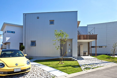Imagen de fachada de casa gris de dos plantas con revestimientos combinados y tejado plano