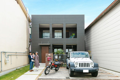 Idées déco pour une façade de maison noire asiatique de taille moyenne et à un étage avec un revêtement mixte, un toit en appentis et un toit en métal.