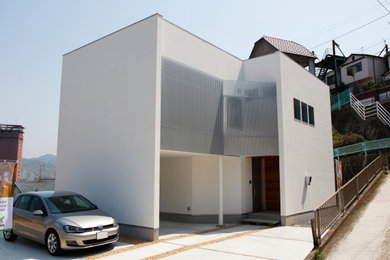 Ejemplo de fachada de casa blanca moderna de tamaño medio de dos plantas con tejado de metal y tejado plano
