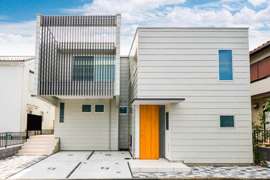 Imagen de fachada de casa gris contemporánea pequeña de dos plantas con tejado de metal, revestimiento de vinilo y tejado plano