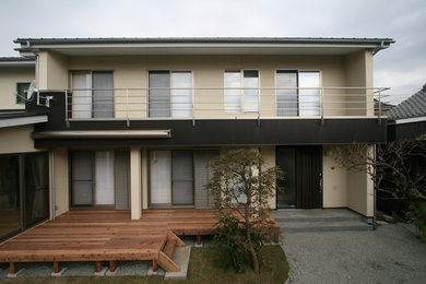 Cette photo montre une façade de maison beige tendance avec un toit à deux pans.