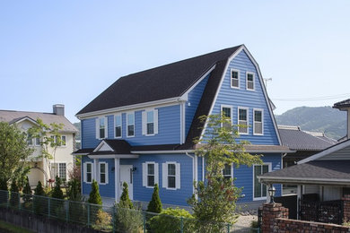 Imagen de fachada de casa azul tradicional de tamaño medio de dos plantas con revestimientos combinados y tejado a dos aguas