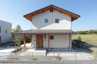 Ejemplo de fachada de casa blanca asiática de dos plantas con tejado a dos aguas y tejado de teja de barro