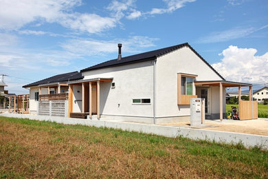 Diseño de fachada de casa blanca de una planta con revestimiento de estuco y tejado de teja de barro