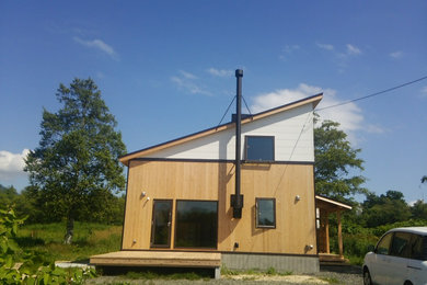 Diseño de fachada de casa de dos plantas con revestimiento de madera, tejado de un solo tendido y tejado de metal