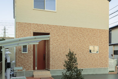 Exemple d'une façade de maison beige nature avec un revêtement mixte.