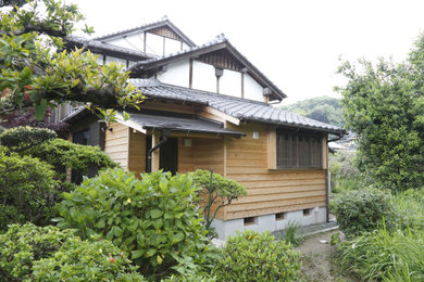 Diseño de fachada de casa beige asiática de tamaño medio de dos plantas con revestimiento de madera