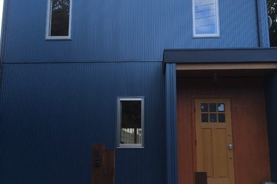 Modelo de fachada de casa azul de dos plantas con revestimiento de metal