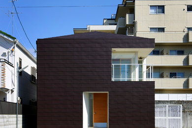 Imagen de fachada negra minimalista de dos plantas con revestimiento de madera y tejado a cuatro aguas