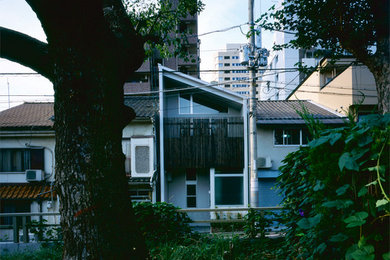 Exemple d'une façade de maison blanche tendance à un étage avec un revêtement mixte et un toit en appentis.