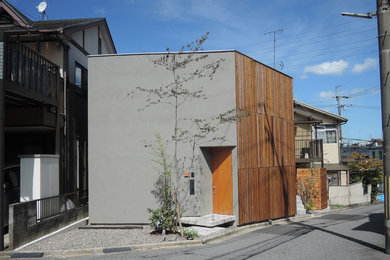 Modelo de fachada de casa gris asiática de dos plantas con revestimientos combinados y tejado plano