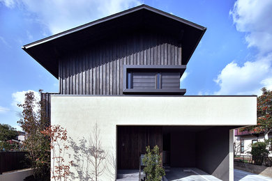 Ejemplo de fachada de casa blanca asiática de tamaño medio de dos plantas con revestimiento de madera, tejado a dos aguas y tejado de metal