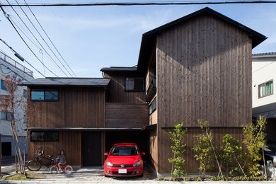 Diseño de fachada de casa marrón actual pequeña a niveles con revestimiento de madera, tejado a dos aguas y tejado de metal