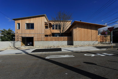 Inspiration for a mid-sized scandinavian two-story wood house exterior remodel in Nagoya with a shed roof and a metal roof