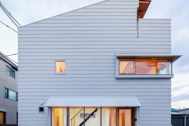 Foto de fachada de casa blanca de estilo zen pequeña de dos plantas con revestimiento de metal y tejado de metal