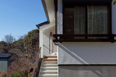 Immagine della villa bianca a un piano con rivestimento in stucco, tetto a capanna e copertura in metallo o lamiera