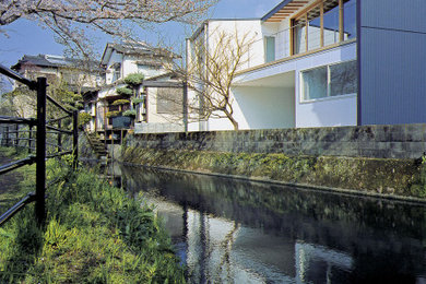 Imagen de fachada de casa moderna de tamaño medio de dos plantas con tejado de un solo tendido y tejado de metal