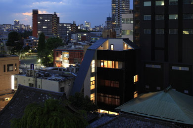 Imagen de fachada de casa de estilo zen de tres plantas con tejado a doble faldón y tejado de metal