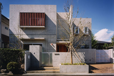 Mid-sized minimalist gray two-story concrete exterior home photo in Osaka