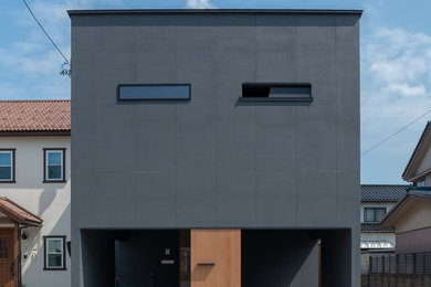 Aménagement d'une façade de maison noire moderne à un étage avec un toit en appentis et un toit en métal.