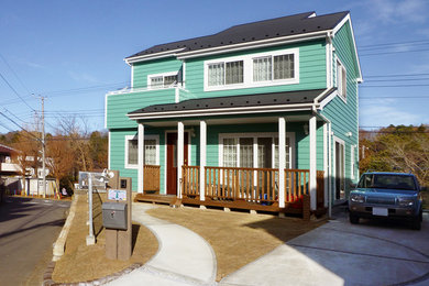 他の地域にあるカントリー風のおしゃれな二階建ての家 (混合材サイディング、緑の外壁) の写真