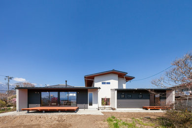 Inspiration pour une façade de maison grise design avec un toit à deux pans.