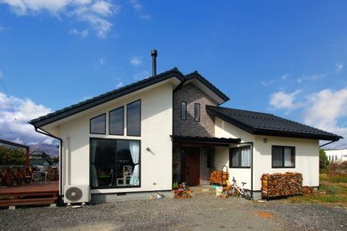 Modelo de fachada de casa blanca de estilo de casa de campo de tamaño medio de dos plantas con revestimientos combinados, tejado a cuatro aguas y tejado de teja de barro
