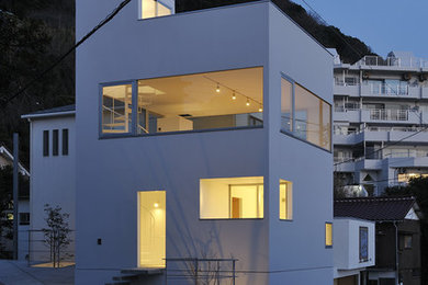 Ejemplo de fachada de casa gris minimalista pequeña de tres plantas con revestimiento de aglomerado de cemento, tejado plano y tejado de varios materiales