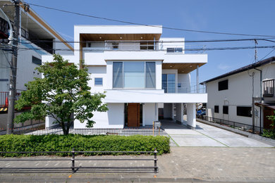 Modelo de fachada de casa blanca contemporánea de tres plantas con tejado plano