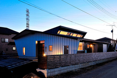 Modelo de fachada gris minimalista con revestimiento de metal y tejado a dos aguas