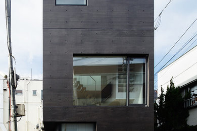 Foto de fachada de casa negra actual de tres plantas con revestimiento de hormigón y tejado plano
