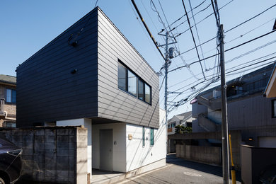 Small minimalist two-story concrete fiberboard apartment exterior photo in Tokyo with a shed roof and a metal roof
