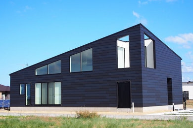 Foto de fachada de casa negra de tamaño medio de dos plantas con revestimiento de metal, tejado de un solo tendido y tejado de metal