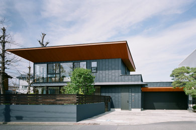 Imagen de fachada de casa negra minimalista grande de dos plantas con tejado de un solo tendido, tejado de metal y revestimiento de metal