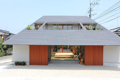 White and large contemporary two floor detached house in Fukuoka with a lean-to roof.