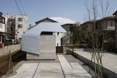Imagen de fachada de casa gris minimalista de dos plantas con revestimiento de hormigón y tejado de metal