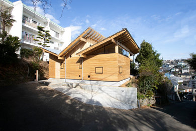 Foto de fachada de casa de estilo americano pequeña de una planta con revestimiento de madera, tejado de un solo tendido y tejado de metal